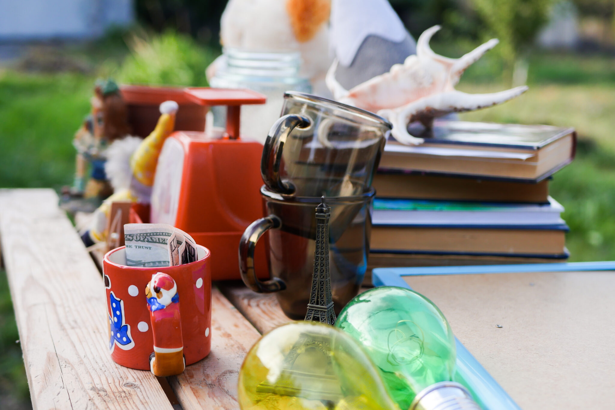 Ein Tisch, worauf tassen stehe, Glüghlampen und Bücher liegen uns vieles mehr.