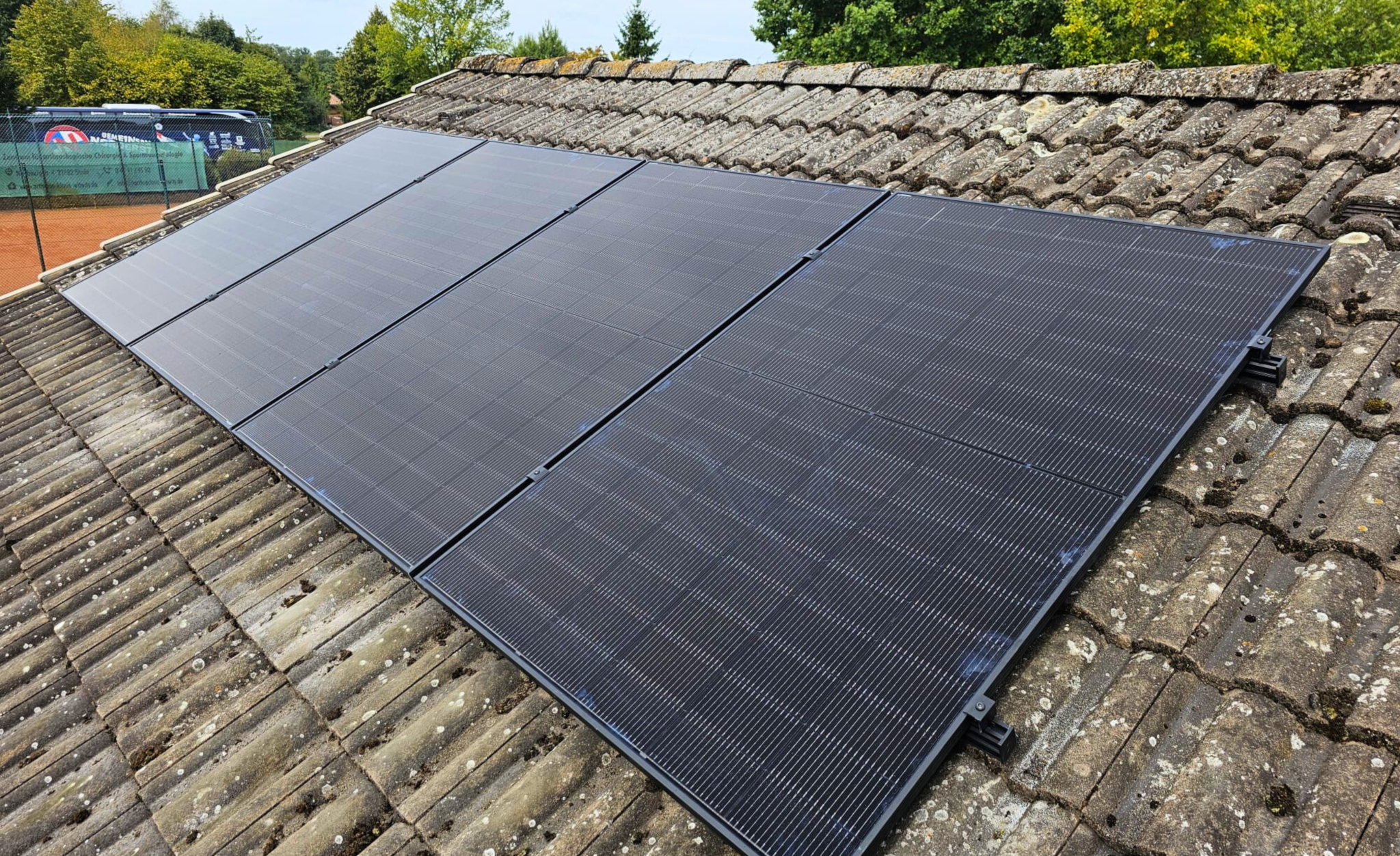 Vier Solarpanele auf einem Dach.