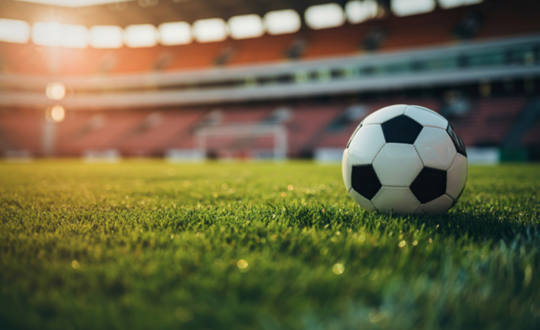 Nahaufnahme eines Fußballs, der auf dem Rasen eines Spielfeldes liegt.