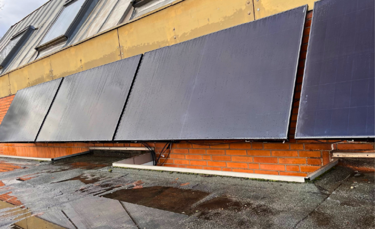 Vier Solarpanele an einer roten Ziegelwand