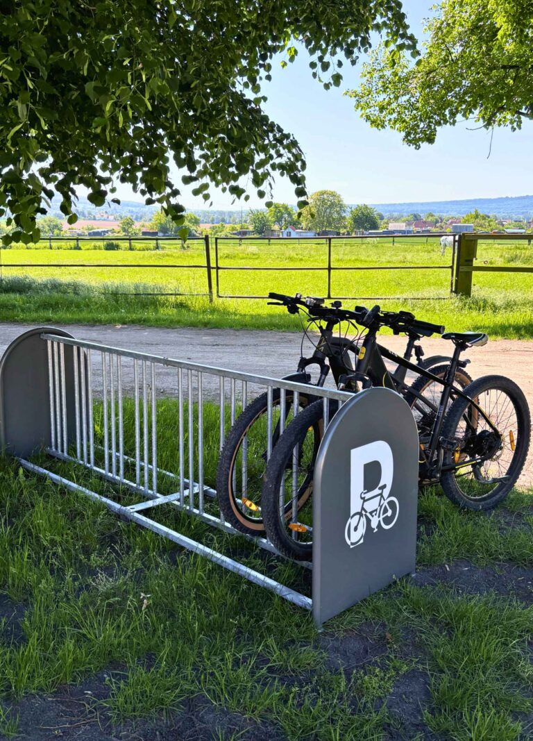 Vor einer Pferdekoppel steht der neue Fahrradständer mit zwei angeschlossenen Fahrrädern.