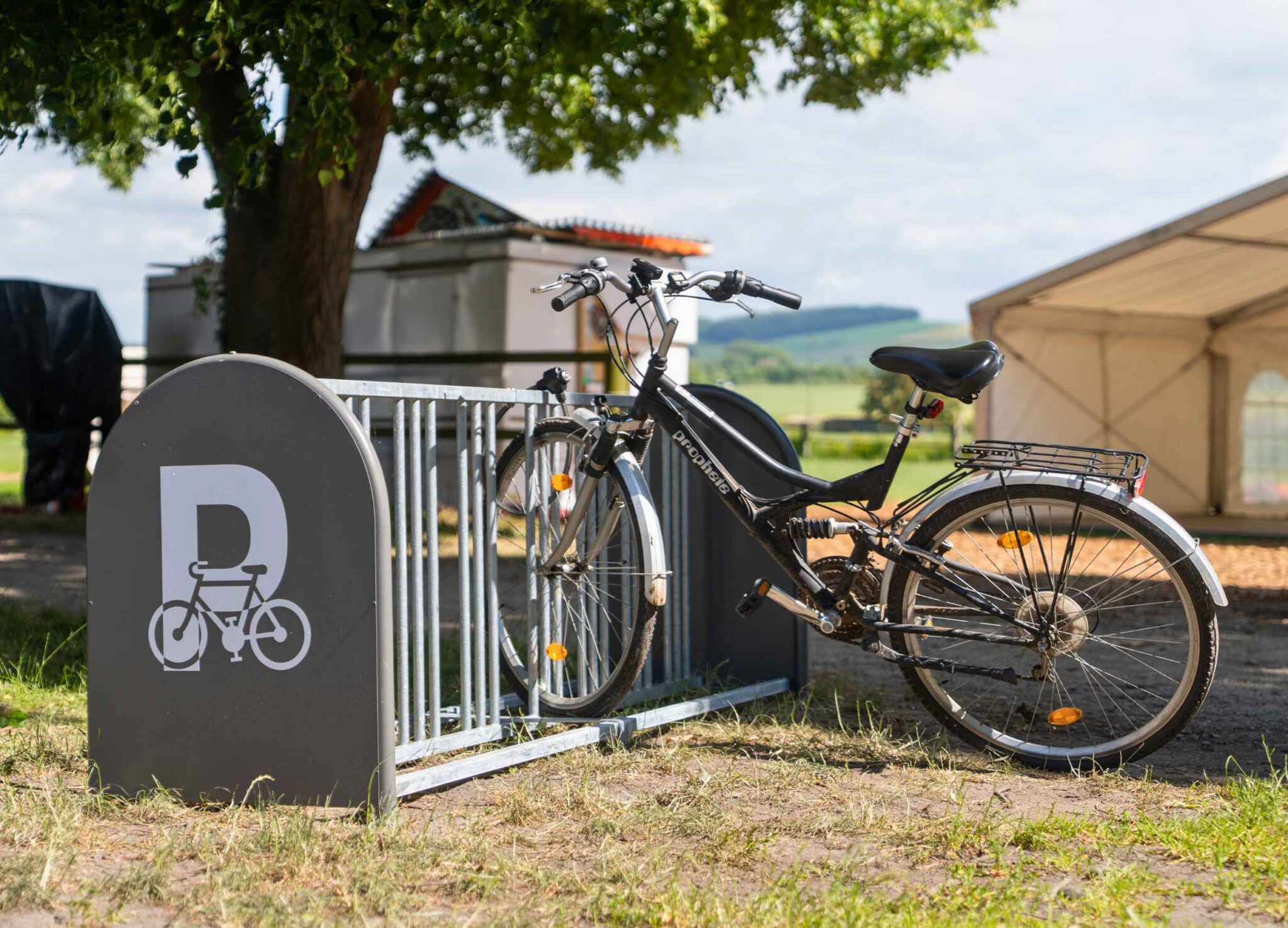 Eine Nahaufnahme von einem Fahrradständer mit einem angeschlossenen Fahrrad auf dem Gelände eines Sportvereins.